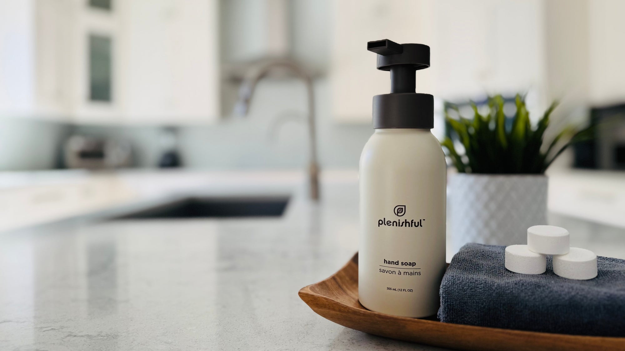 Hand soap bottle on a tray with a blurred kitchen background